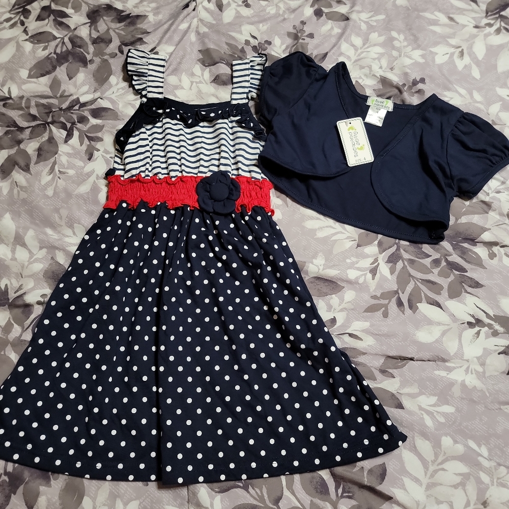 Little girls navy dress with polka dots, red accent at waist, and bolero jacket